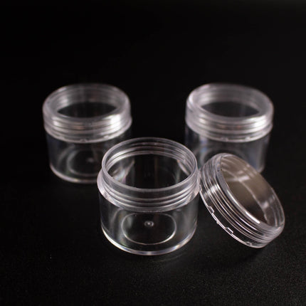 Three transparent plastic jars with clear lids are arranged on a black background.