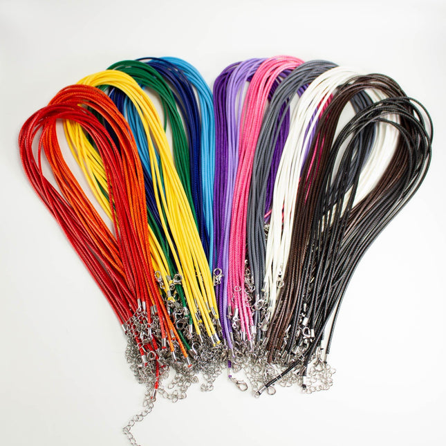 A collection of colorful braided necklaces made of various materials, including red, yellow, green, blue, purple, pink, and black.