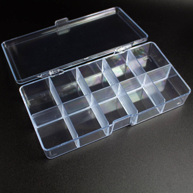 A clear plastic container with multiple compartments, sitting on a dark surface.