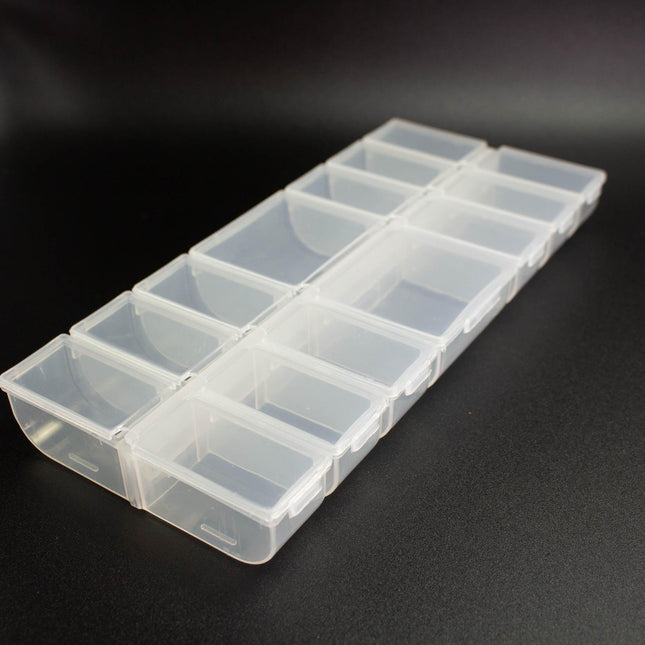 A clear plastic container with multiple compartments, sitting on a black surface.