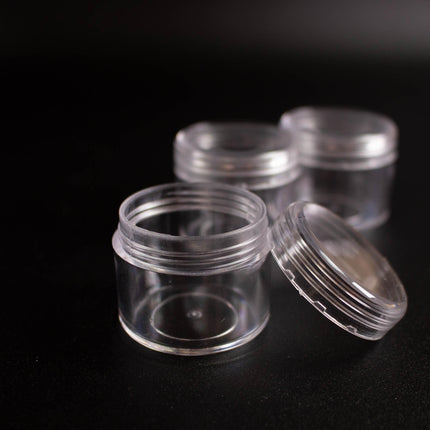 a collection of clear plastic containers or jars on a black background.