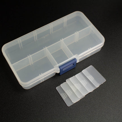 A clear plastic container with multiple compartments, and a set of clear plastic cards or labels next to it, both placed on a dark surface.