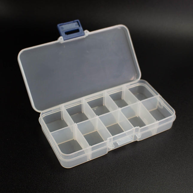 An open plastic container with multiple compartments, sitting on a black surface.