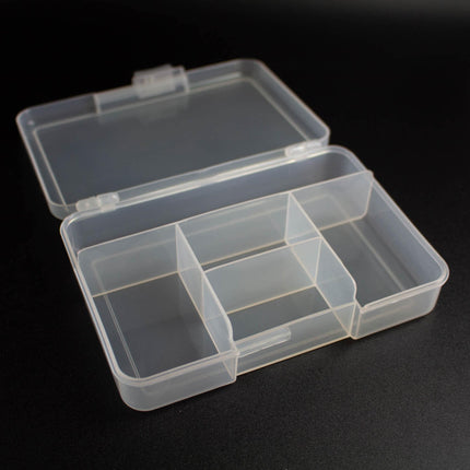 An open plastic container with multiple compartments, sitting on a black surface.