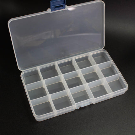 An open plastic container with multiple compartments, sitting on a black surface.