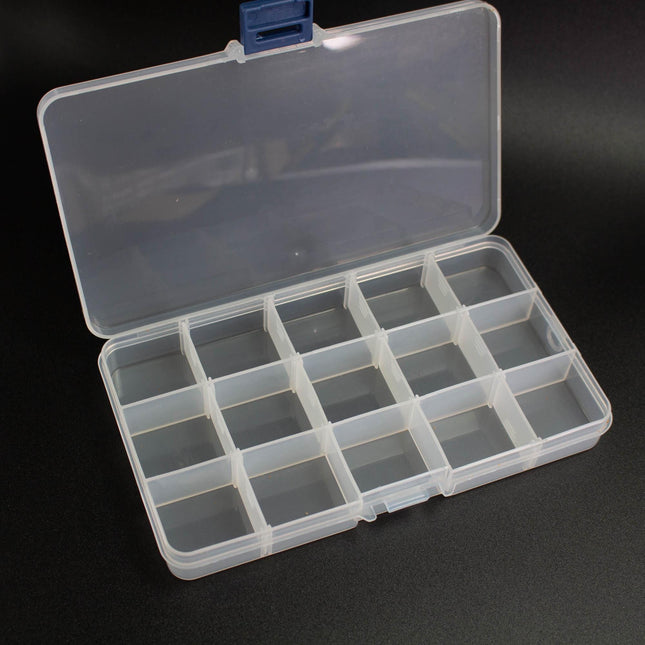 An open plastic container with multiple compartments, sitting on a black surface.