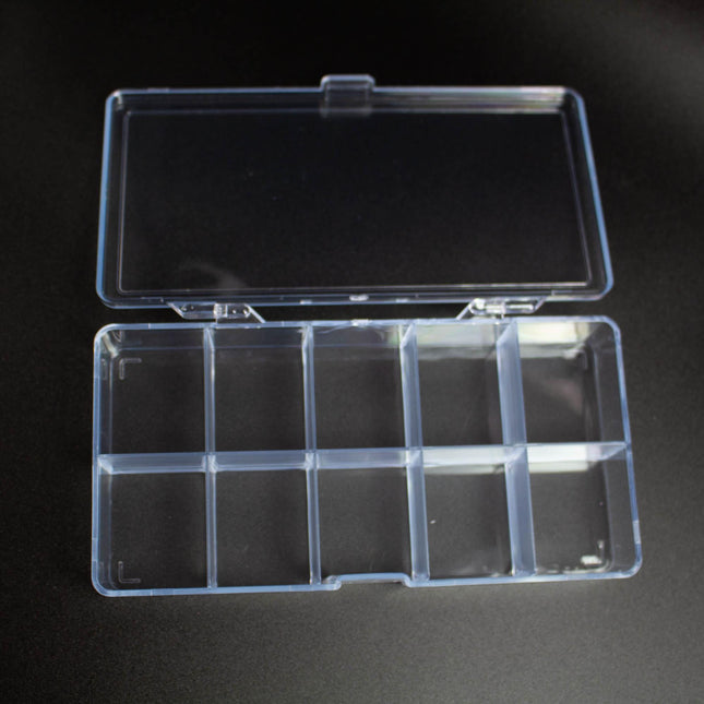 A clear plastic container with nine compartments is shown on a black surface.