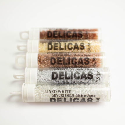 five containers of Delicas brand beads, each with a different color and size.