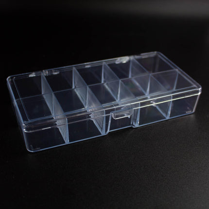 A clear plastic container with multiple compartments, sitting on a dark surface.