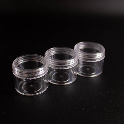 Three transparent plastic containers of different sizes are arranged in a row on a black background.