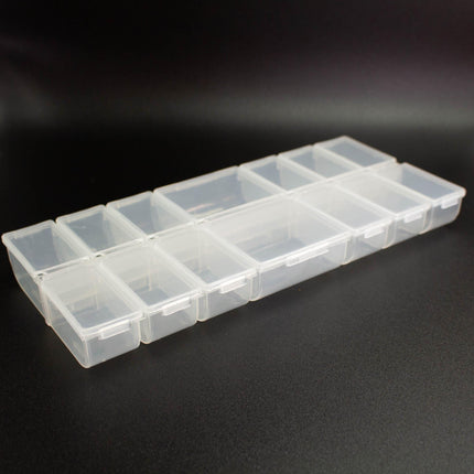 A row of clear plastic containers with compartments, arranged on a black surface.