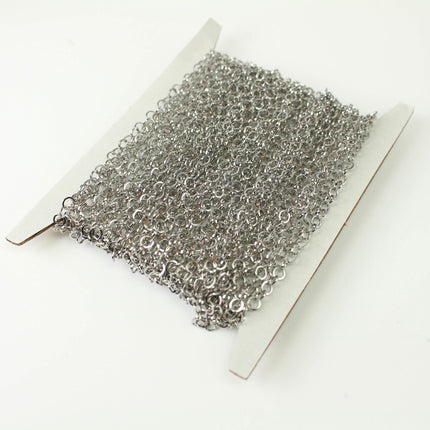 A spool of silver chain with numerous small links, likely used for crafting or jewelry-making purposes.