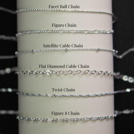 a collection of various silver chain necklaces, each with different designs and styles, arranged in a row.
