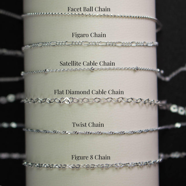 a collection of various silver chain necklaces, each with different designs and styles, arranged in a row.