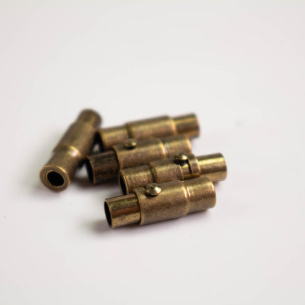 A group of brass-colored metal pieces, possibly lock components, are arranged on a white surface.