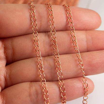 A close-up image of a person's hand holding a chain with multiple links.