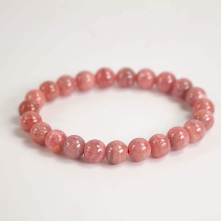 A bracelet made of pink beads arranged in a circular pattern.