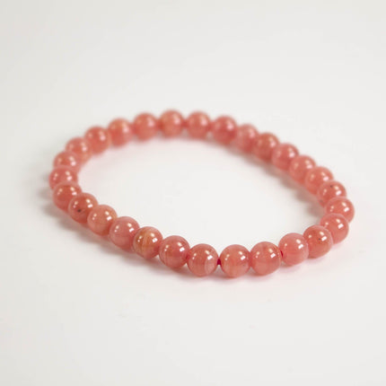 A bracelet made of small, round beads in a vibrant red color.