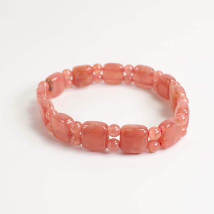 A bracelet made of small, round, pink beads arranged in a circular pattern.