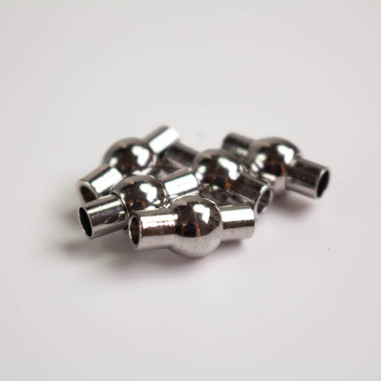 A group of silver-colored metal balls or spheres, possibly used for securing or connecting objects.