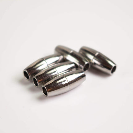 A group of shiny metal objects, possibly lock components, are arranged on a white surface.