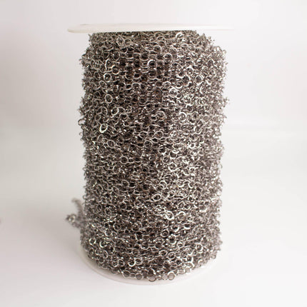 A cylindrical object filled with numerous small silver-colored metal links, creating a dense, textured appearance.