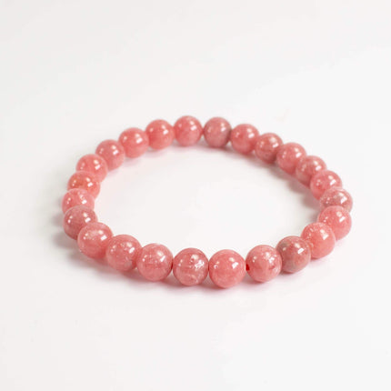 A bracelet made of small, round, pink beads arranged in a circular pattern.