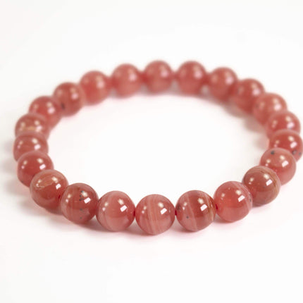 A bracelet made of red beads arranged in a circular pattern.