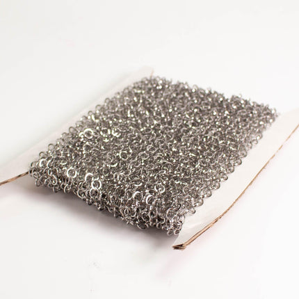 A close-up image of a piece of silver-colored metal mesh or wire, which appears to be a type of kitchen or cleaning tool.